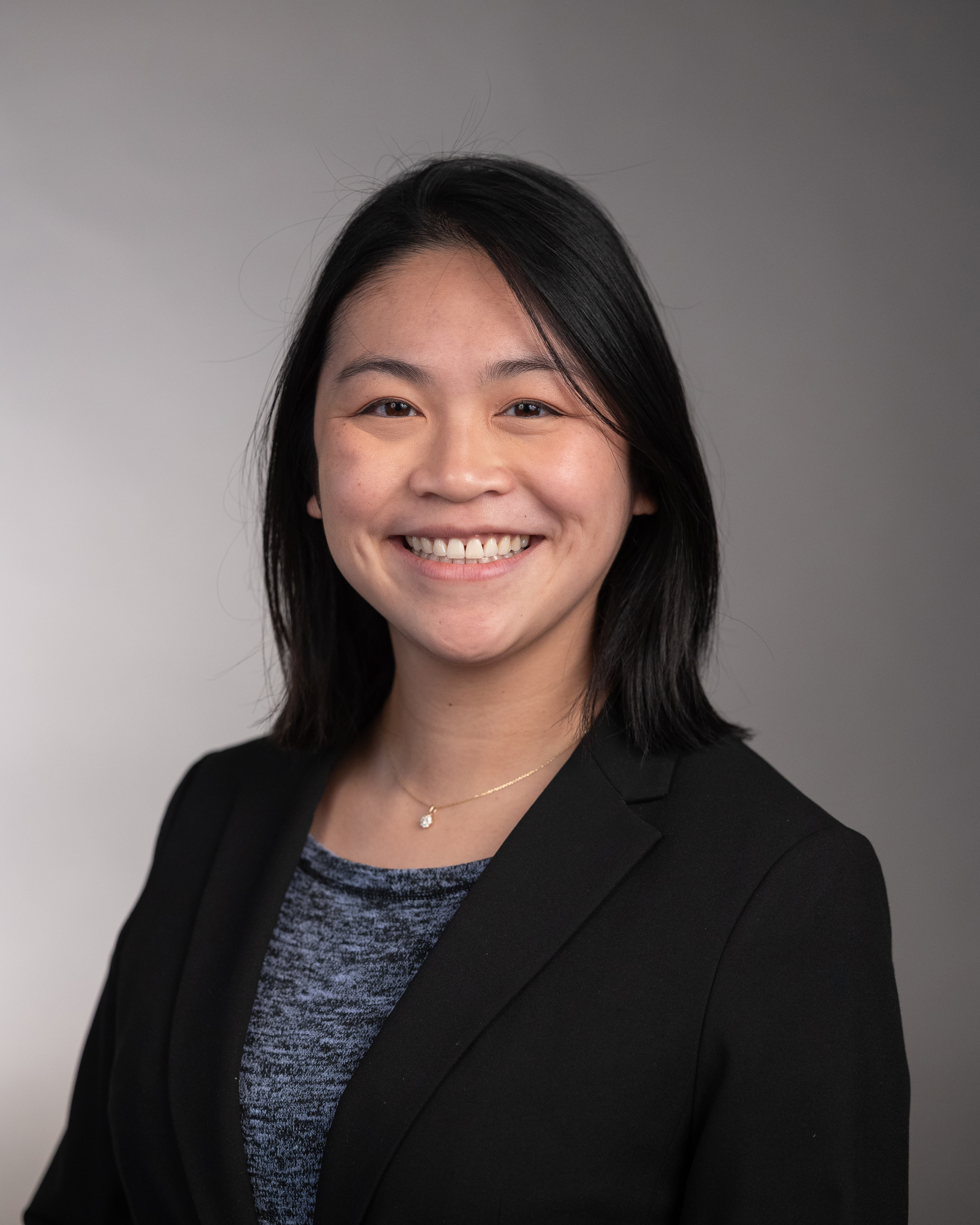 A woman with dark hair smiles in this headshot